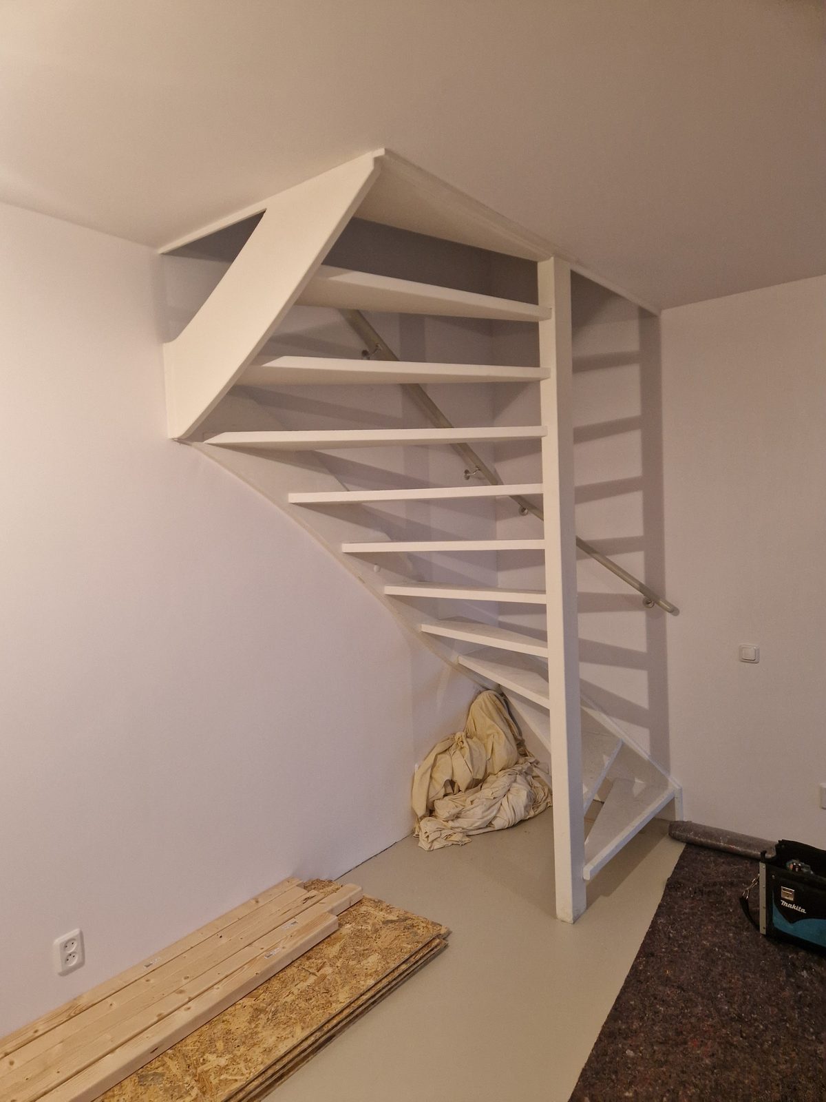 Een nieuwe open witte trap met een kwartslag in een lege kamer